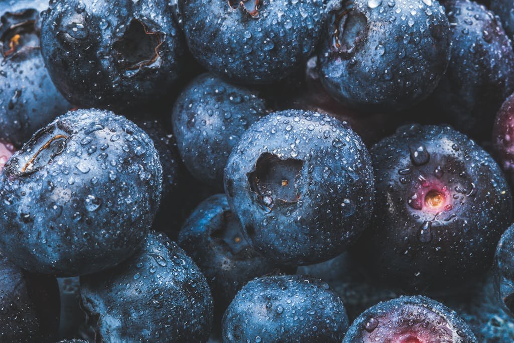 Fresh blueberries covered with water droplets, showcasing their juiciness and vibrant blue color. Perfect for healthy eating concepts.